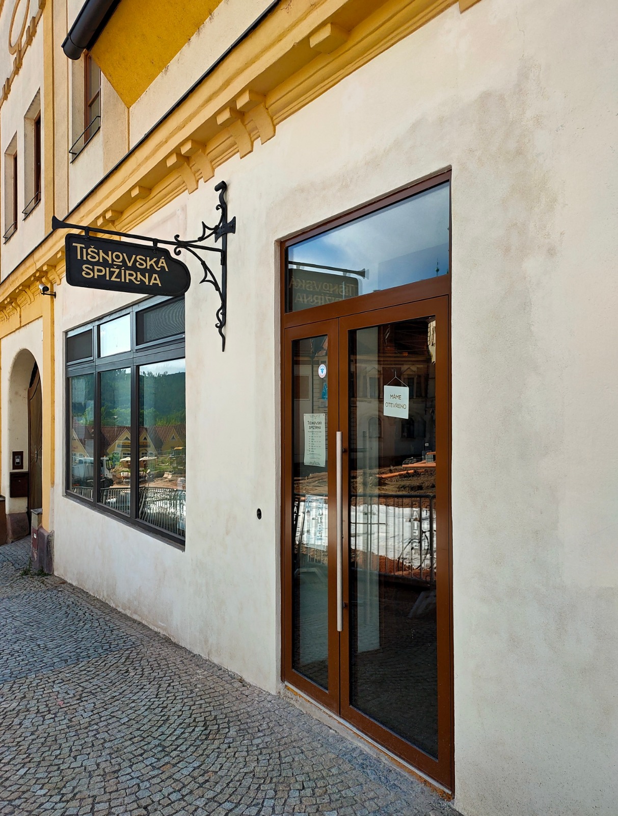 vstupní dveře do obchodu s vývěstním štítem Tišnovská spižírna